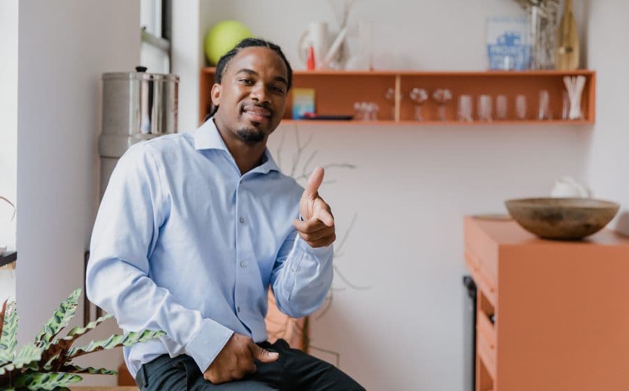 A man giving a thumbs up at home
